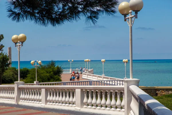 Svaha letoviska Gelendzhik za jasného slunečného počasí. Bílá balustráda a pouliční osvětlení. V pozadí Černého moře — Stock fotografie