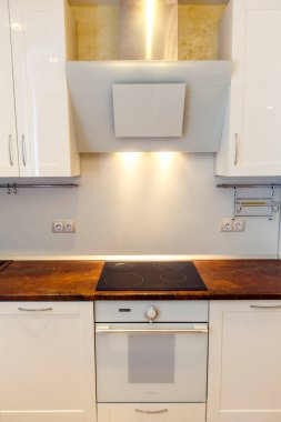 Bej tezgahları ve mutfak aletleri olan modern beyaz mutfak..