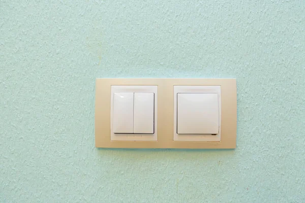 Light green wall with textured plaster and a beige light switch on it — Stock Photo, Image