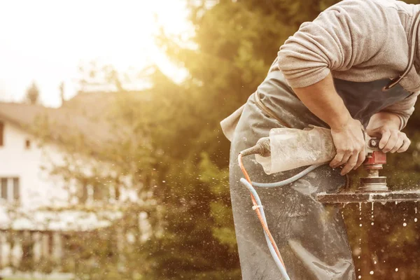 Bricoleur travaillant avec rectifieuse sur une plaque de pierre dans le s — Photo