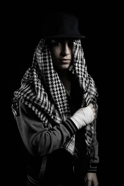 Jeune rappeur avec bonnet et écharpe devant fond noir — Photo