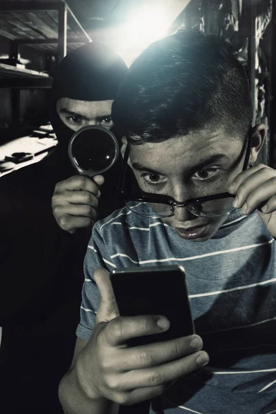 Maskovaný muž špionáž data ze smartphone teenagera — Stock fotografie