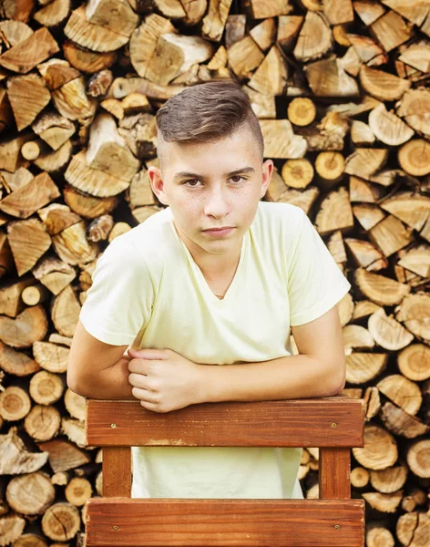 Chico serio con peinado delante de tronco de madera — Foto de Stock