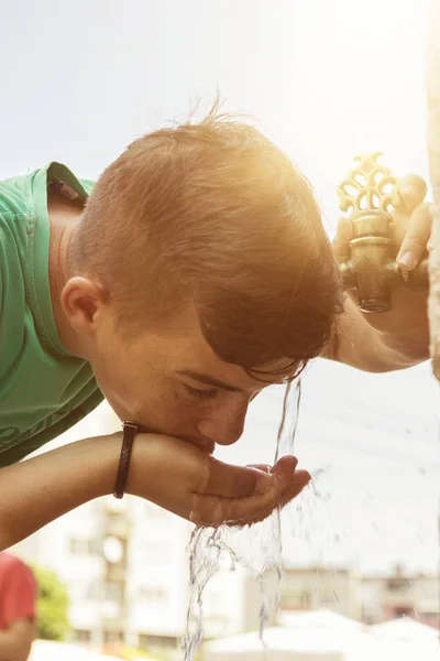 Boy drinking water from oriental tap in the city of prizren — Stock Photo, Image