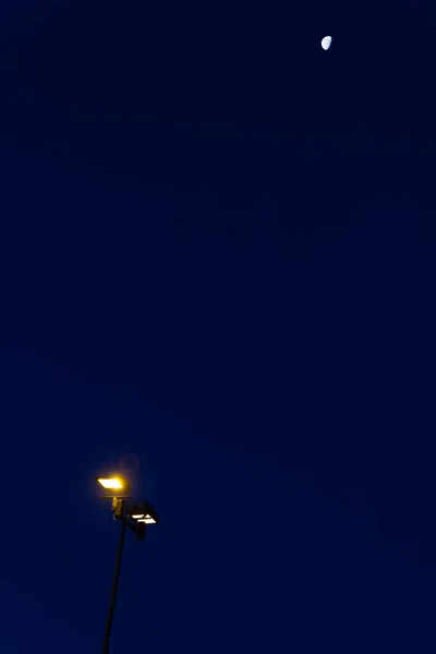 Luna deasupra lampii stradale noaptea — Fotografie, imagine de stoc