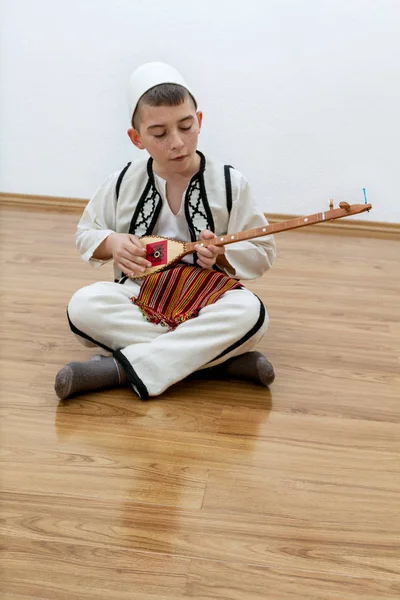 Chico joven tocando instrumento de cuerda tradicional —  Fotos de Stock