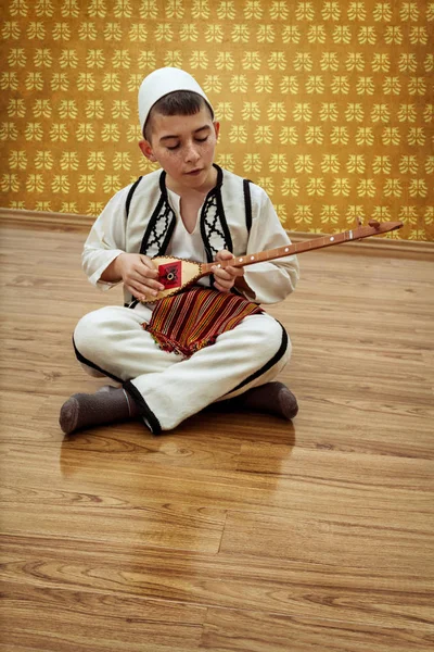 Chico joven tocando instrumento de cuerda tradicional —  Fotos de Stock