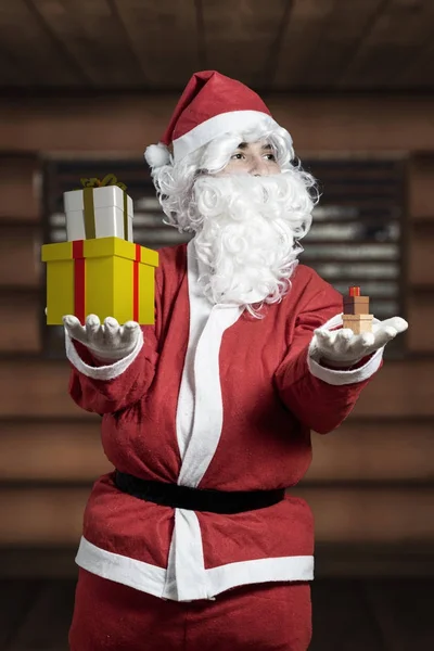 Santa Claus posiadają duże prezenty na prawej dłoni i drobne upominki na — Zdjęcie stockowe