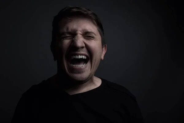 Portrait of man yell of pain in front of grey background — Stock Photo, Image