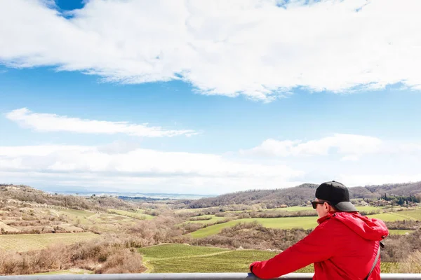 Tourist mit roter Jacke mit Blick auf die Weinberge der Toscana, ita — Stockfoto