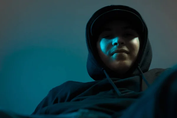 Jong cool glimlachen rapper met zwart hoodie en cap naar beneden kijken — Stockfoto