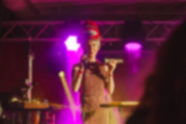 Singer woman on stage. Abstract blurred image