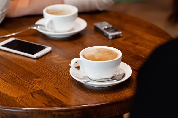 Two people drinking coffee in the interview process in a cafe