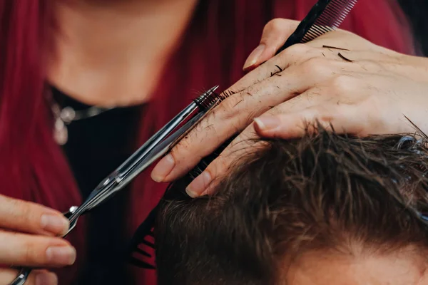 Man getting a haircut by hairdresser at the salon