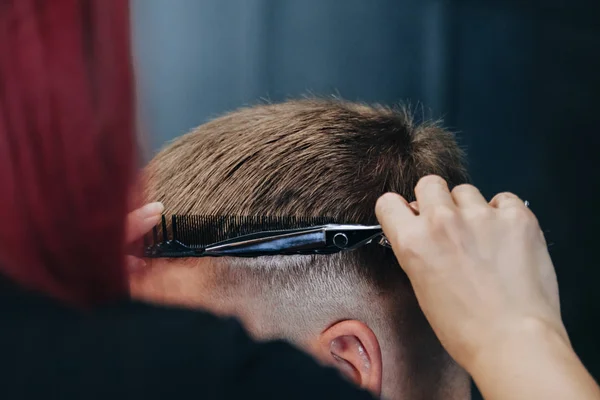 Man getting a haircut by hairdresser at the salon