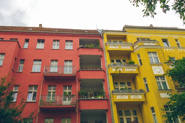 red and yellow houses in a row with big balconies