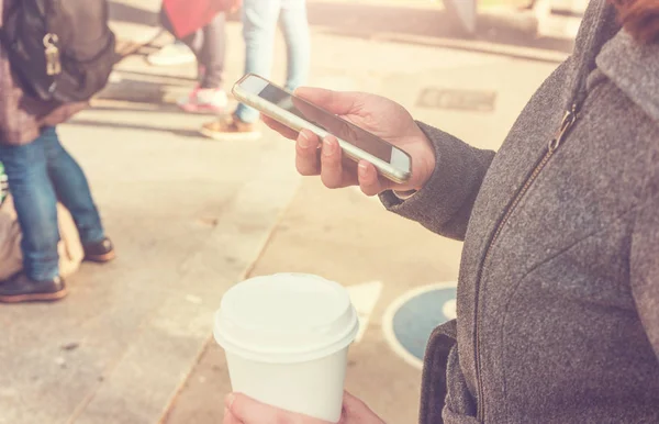 Smartphone ve kadının elinde kahve — Stok fotoğraf