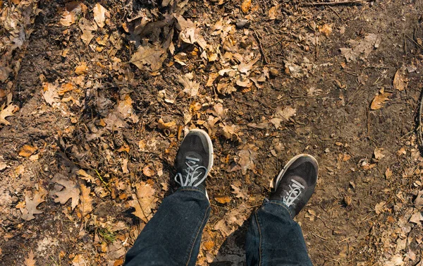 Fötter av en person som bär svart sneakers — Stockfoto