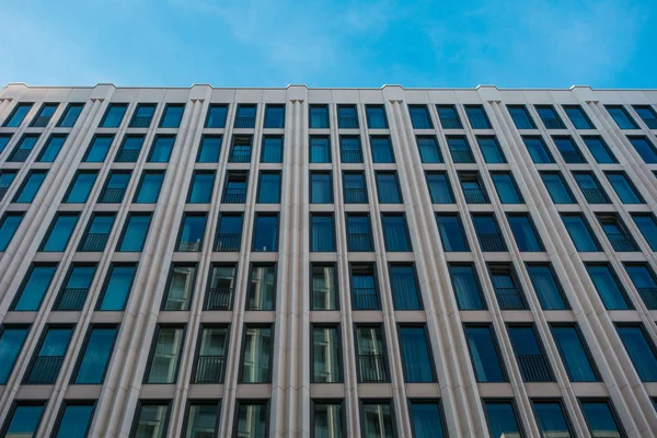 Большое офисное здание с маленькими голубыми окнами — стоковое фото