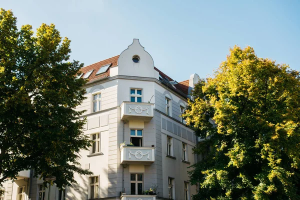 Yeşil ağaçlar arasında beyaz köşeli ev