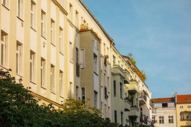 Önünde gölgesi olan sarı apartman dairesi