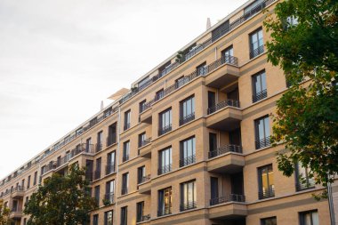 Turuncu, modern, büyük balkonlu bir apartman.