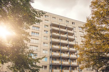Sonbaharda tipik bir plattenbau binası. Güzel ağaçlar ve sıcak mercekler parlıyor.