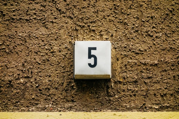 number 5 door sign on brown facade