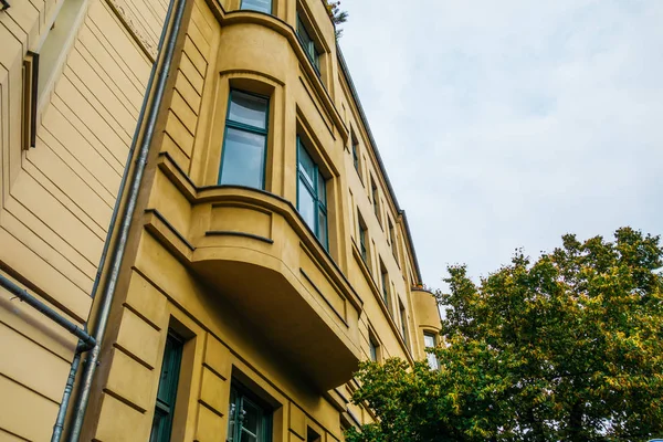 Yeşil ağaçlı sarı apartman.