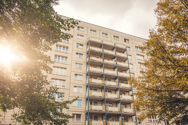 Sonbaharda tipik bir plattenbau binası. Güzel ağaçlar ve sıcak mercekler parlıyor.