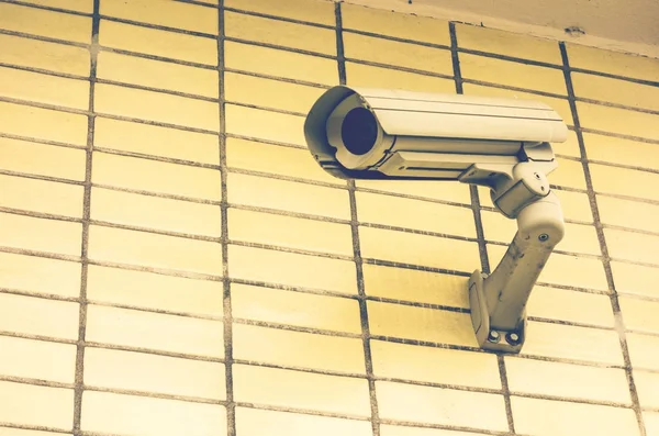 security camera on yellow brick facade