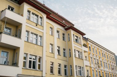 Beyaz sıva detaylı sarı apartman