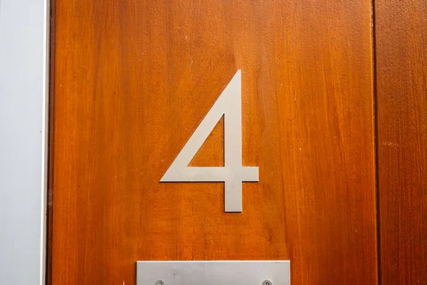 number 4 door sign on wooden facade