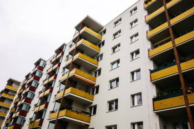 Sarı balkonlu beyaz yüzlü plattenbau binası