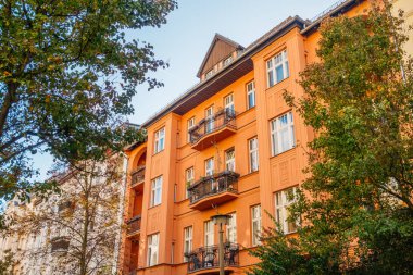 Yeşil ağaçlarla çevrili kırmızı bina.