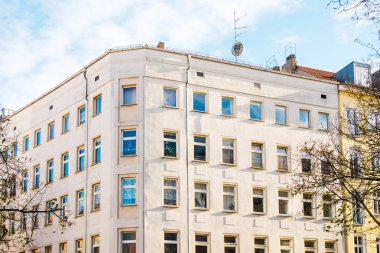 white corner building with fluffy clouds