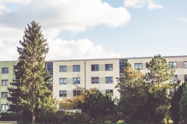 yeşil ağaçlar ve çalılar arasında plattenbau binası