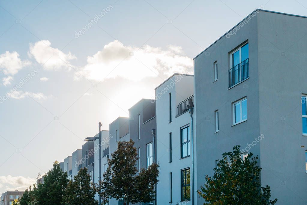 cold colored modern townhouses in a row with lens flare