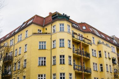 Berlin 'de bulutlu bir arka planda sarı, büyük bir apartman.