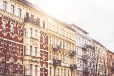 Facades of tenement buildings with balconies at sunset