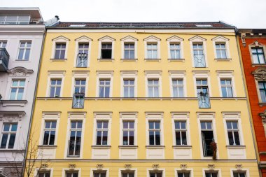 Low angle front view of yellow tenement building