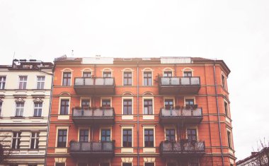 Front view of red tenement building with balconies