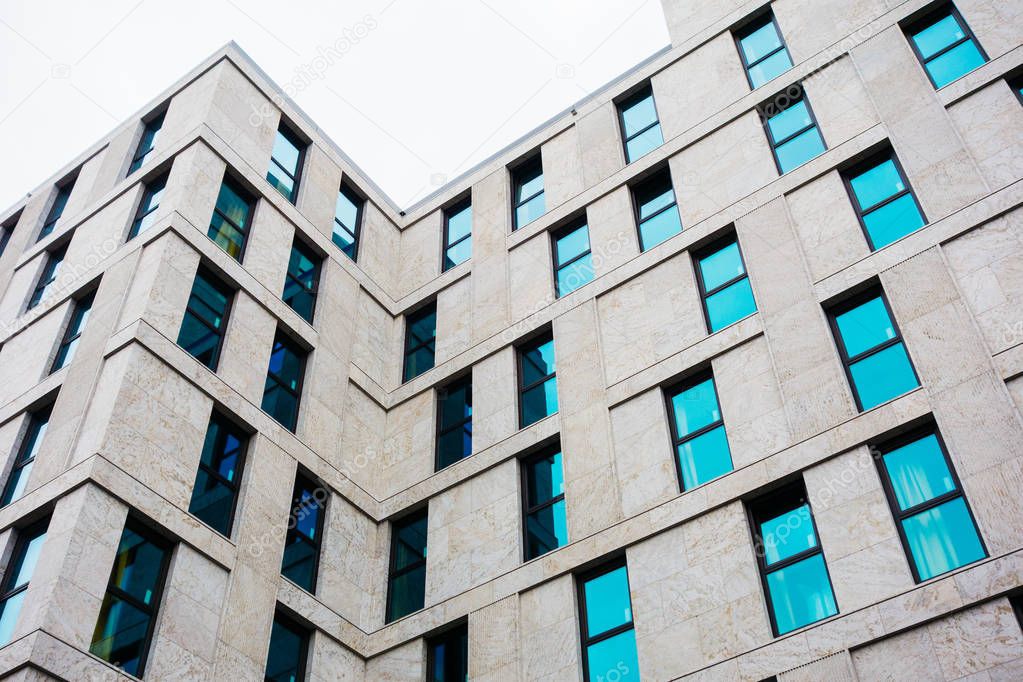 modern apartment facade with cold colored marble details and blue high contrasted windows