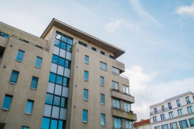 brown apartment house next to an white facaded building