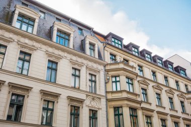 residential houses with stucco facade and fluffy white clouds