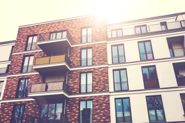 high contrasted brick apartment building with lens flare on the top