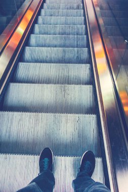 Yürüyen merdivende duran adam.