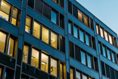 darken office building at night with yellow windows