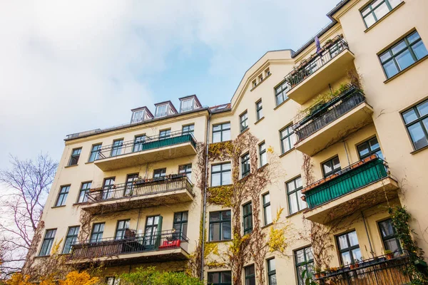 beautiful apartment building with ivy on balcony and colorful facade