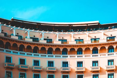 curved building with long orange balcony